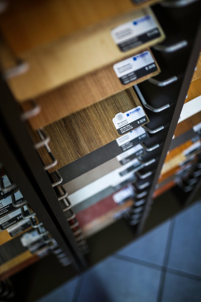about-bg Close-up of various laminated wood veneer samples in a showroom display rack.
